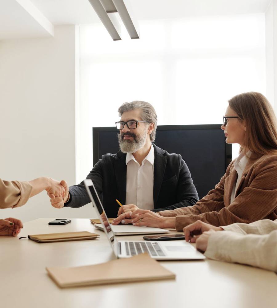A candidate shaking hands with a hiring team after an interview
