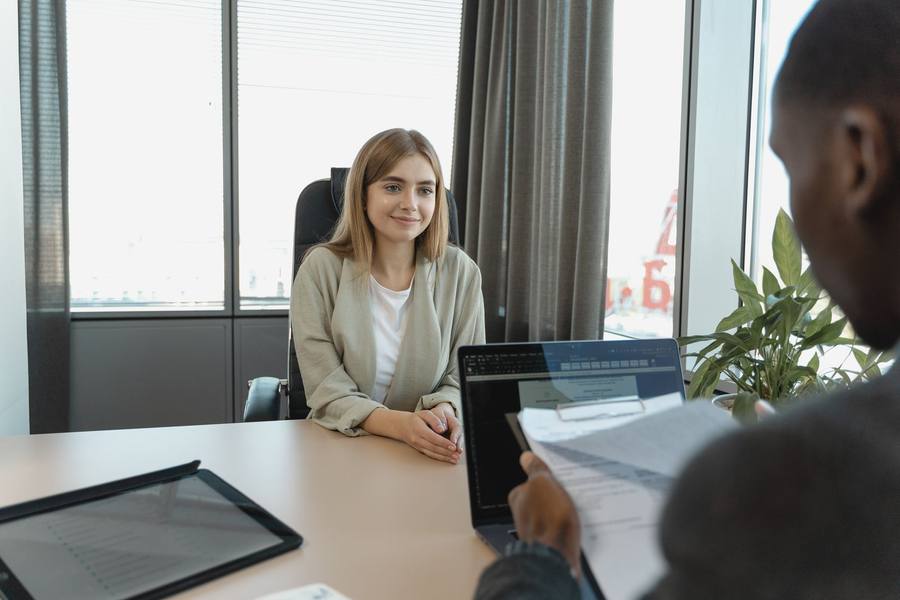 Candidate smiling during an interview with a recruiter reviewing her resume